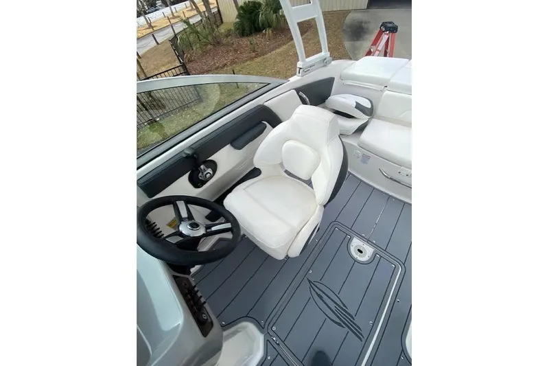 Slide: The Image of 2023 Chaparral 210 SSi boat interior with white seating and sleek steering wheel. - 6
