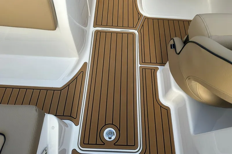 Slide: The Image of 2026 Bayliner VR6 Bowrider OB interior with teak-style flooring and beige seating. - 25