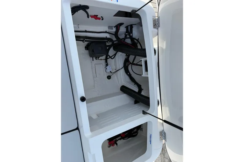 Slide: The Image of 2026 Sea Ray SPX 210 Outboard storage compartment with visible wiring and components. - 12
