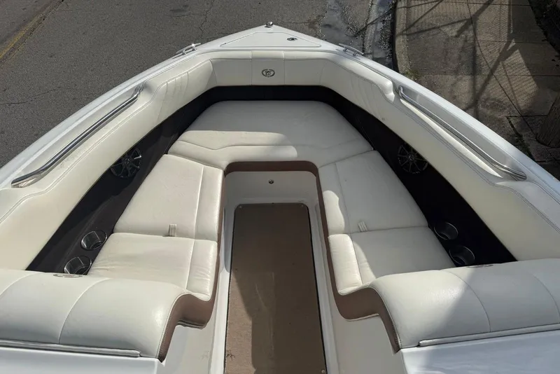 Slide: The Image of 2013 Cobalt 232 boat interior with white cushioned seating and cup holders. - 11