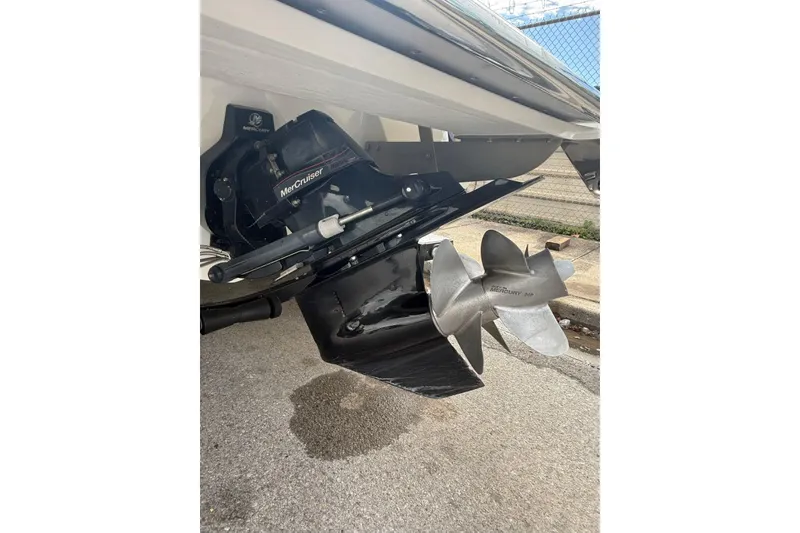 Slide: The Image of 2013 Cobalt 232 boat with MerCruiser outdrive and propeller, parked on pavement. - 27