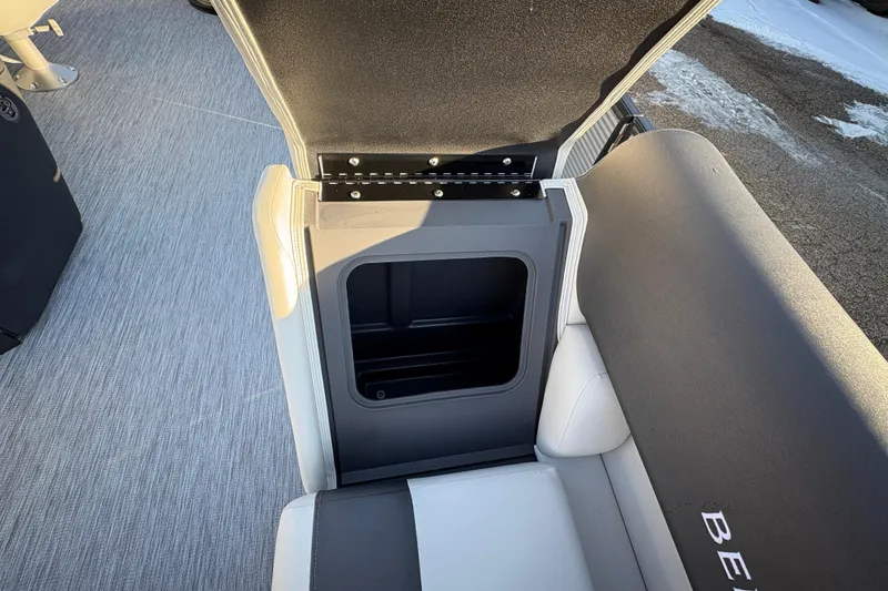 Slide: The Image of 2026 Bennington 22 S-One Swingback seat storage compartment, open view, gray and white interior. - 10