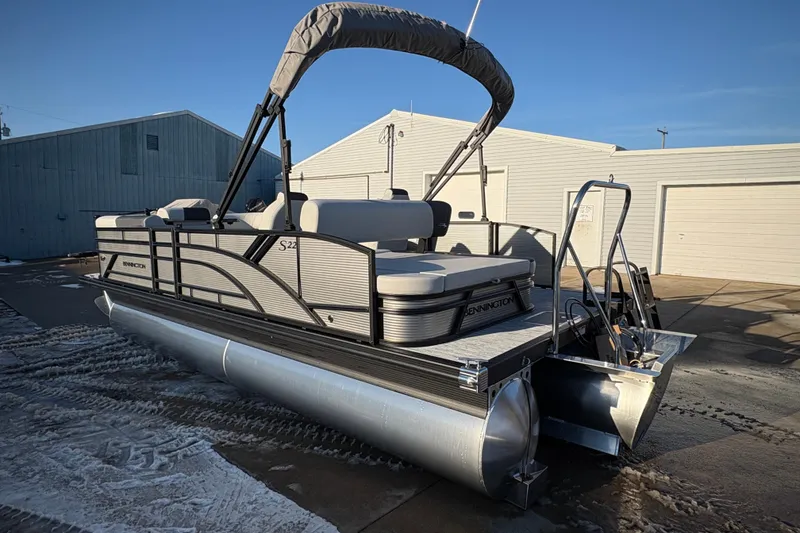 Slide: The Image of 2026 Bennington 22 S-One Swingback pontoon boat with canopy in a sunny outdoor setting. - 2