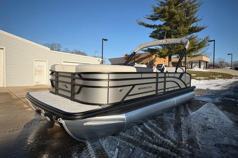 Slide: The Image of 2026 Bennington 22 S-One Swingback pontoon boat parked on snowy pavement. - 3