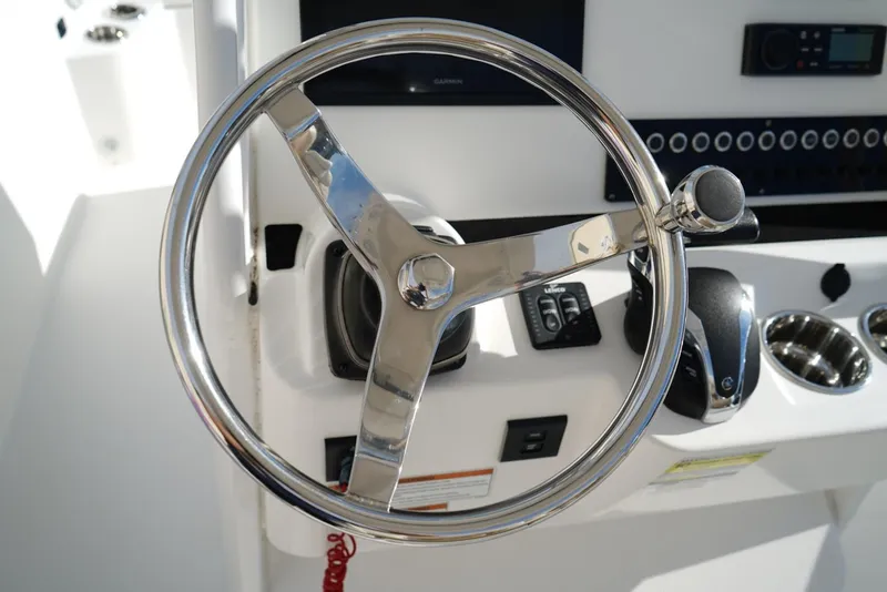 Slide: The Image of Steering wheel of 2021 Edgewater 230CC boat with control panel and throttle. - 13