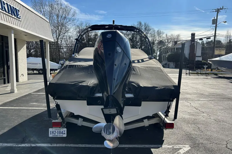 Slide: The Image of 2022 Chaparral 23 SSi OB boat with cover, parked outside a marine dealership. - 11