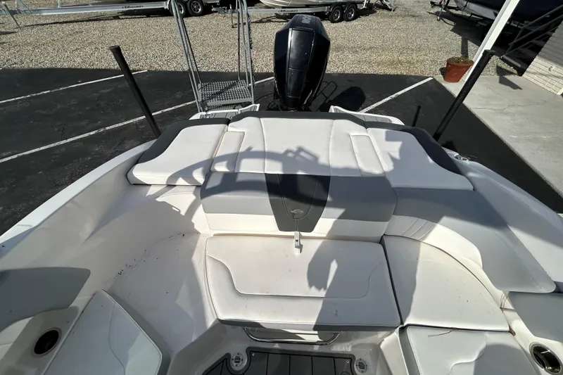Slide: The Image of 2022 Chaparral 23 SSi OB boat interior with cushioned seating and outboard motor. - 20