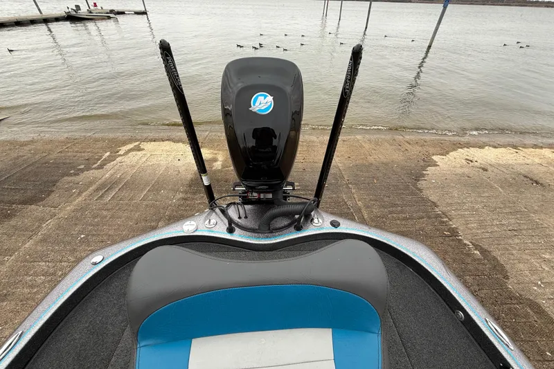 Slide: The Image of 2018 Blazer 625 Pro Elite boat at a lakeside dock with motor and seating. - 31