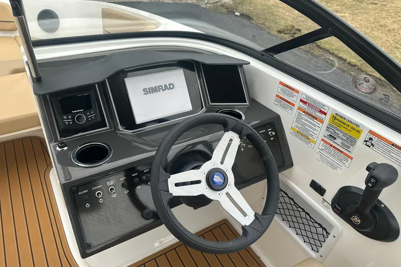 Slide: The Image of 2025 Bayliner VR6 Bowrider OB dashboard with steering wheel and Simrad display. - 11