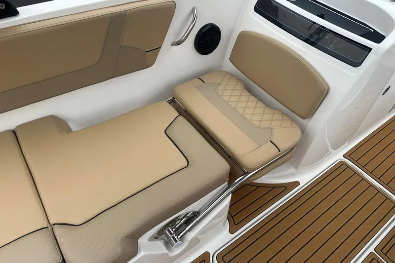 Slide: The Image of 2025 Bayliner VR6 Bowrider OB interior with tan seating and wood-style flooring. - 16