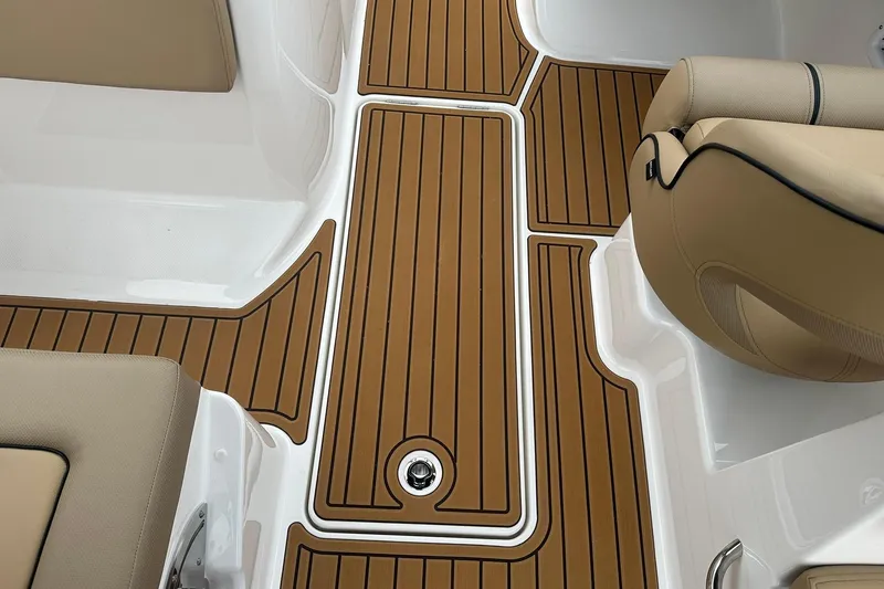Slide: The Image of 2025 Bayliner VR6 Bowrider OB interior with teak-style flooring and beige seating. - 17
