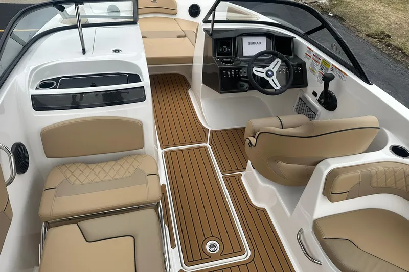 Slide: The Image of 2025 Bayliner VR6 Bowrider OB interior with tan seating and modern dashboard. - 7