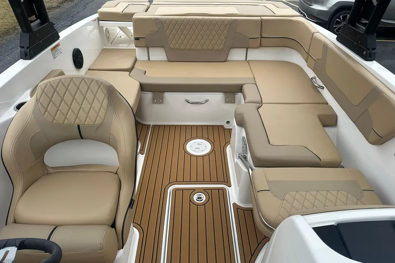 Slide: The Image of 2025 Bayliner VR6 Bowrider OB interior with tan seating and wood-style flooring. - 9