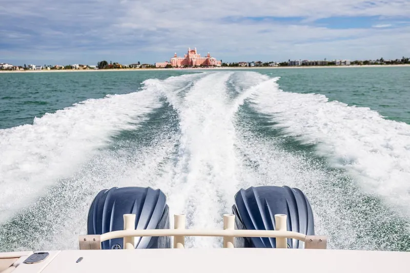 Slide: The Image of 2014 Grady-White Canyon 336 boat cruising, leaving wake, with distant shoreline view. - 10