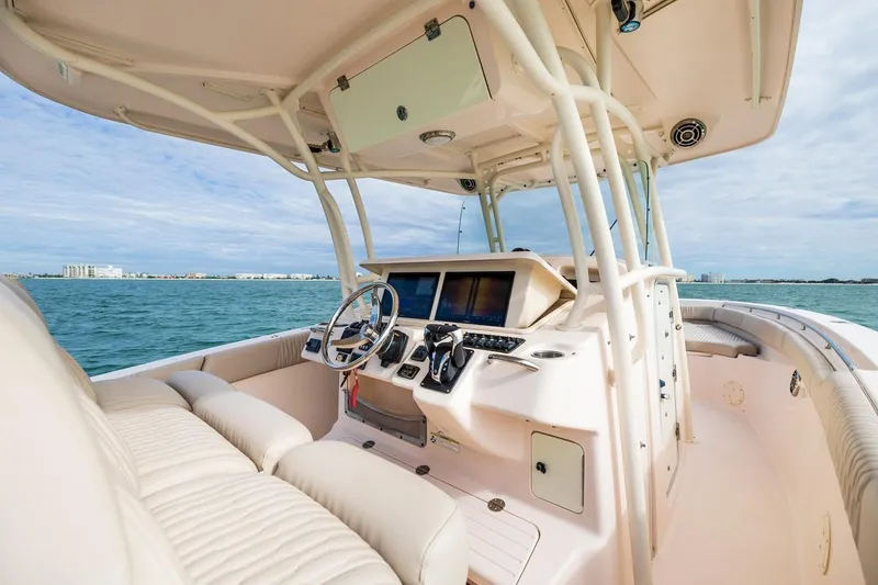 Slide: The Image of 2014 Grady-White Canyon 336 boat interior with helm, ocean view, and modern controls. - 18