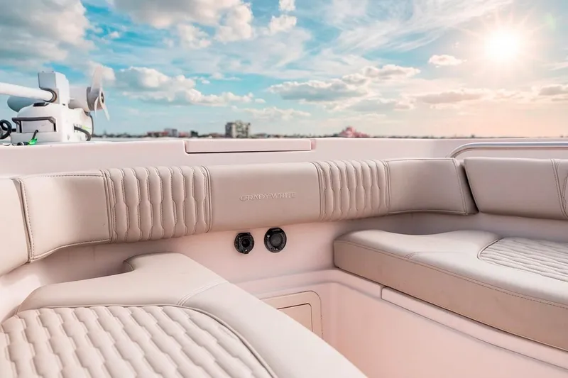 Slide: The Image of 2014 Grady-White Canyon 336 boat interior with plush seating under a sunny sky. - 28