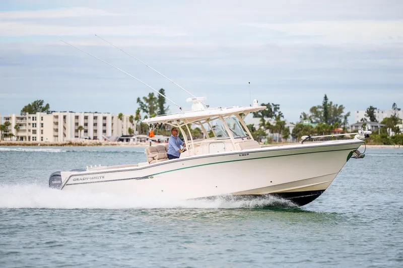 Slide: The Image of 2014 Grady-White Canyon 336 boat cruising on water near coastal buildings. - 3