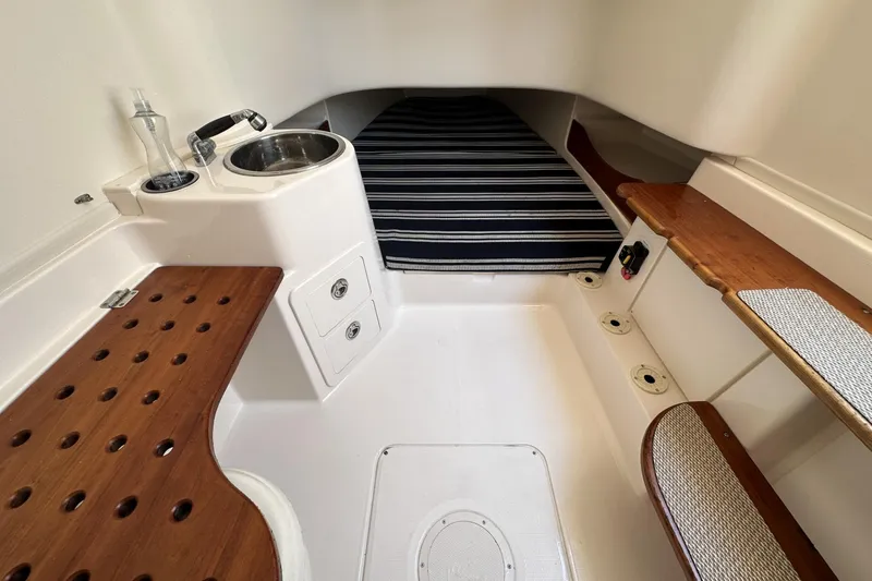 Slide: The Image of 2014 Grady-White Canyon 336 cabin interior with sink, striped bedding, and wooden accents. - 32