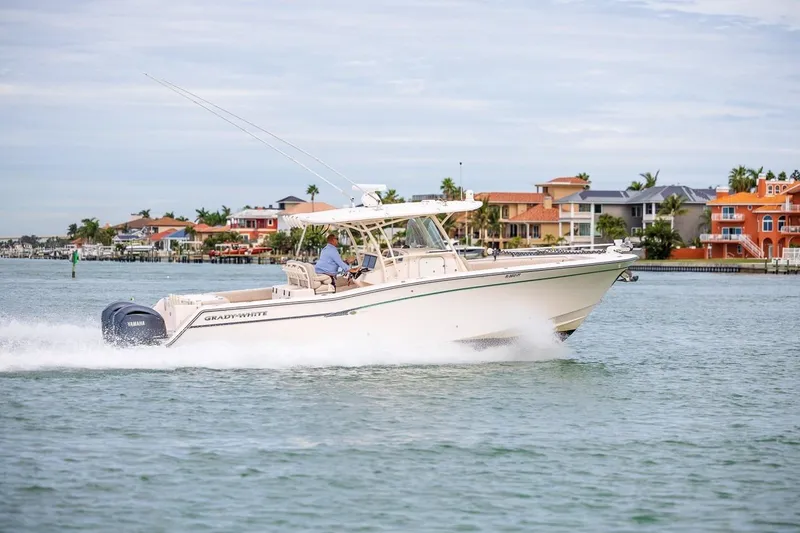 Slide: The Image of 2014 Grady-White Canyon 336 boat cruising near waterfront homes. - 43