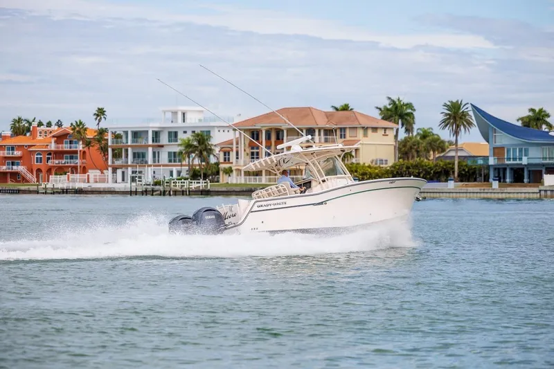 Slide: The Image of 2014 Grady-White Canyon 336 boat cruising near colorful waterfront homes. - 47