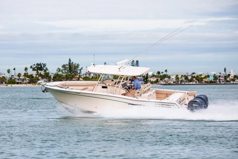 Slide: The Image of 2014 Grady-White Canyon 336 boat cruising on water, showcasing sleek design and powerful engines. - 5