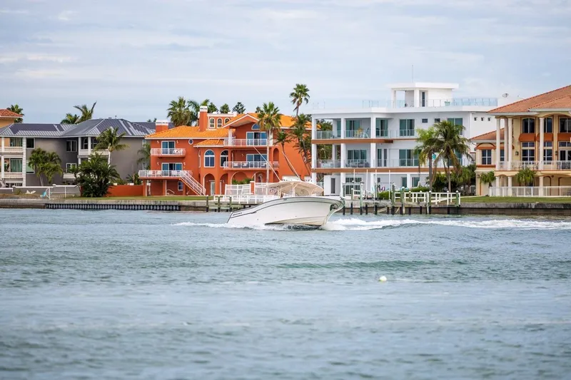 Slide: The Image of 2014 Grady-White Canyon 336 boat cruising near colorful waterfront homes. - 51