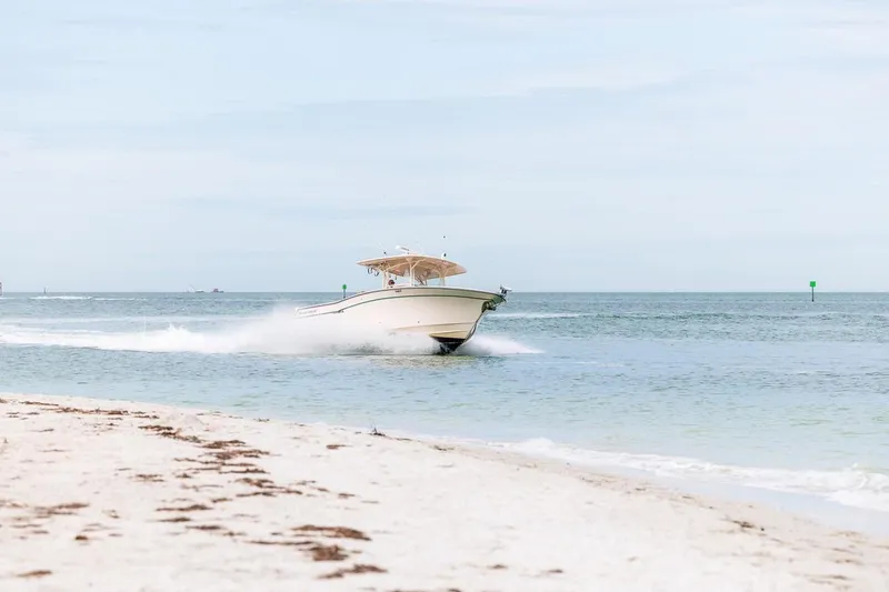 Slide: The Image of 2014 Grady-White Canyon 336 boat cruising near sandy beach. - 58