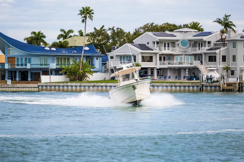 Slide: The Image of 2014 Grady-White Canyon 336 boat cruising near waterfront homes with palm trees. - 59