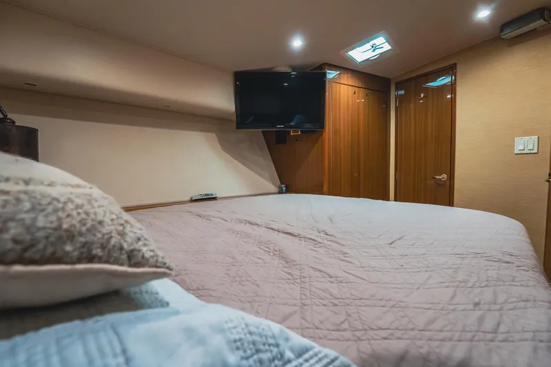 Slide: The Image of Luxurious bedroom interior of 2005 Viking 48 Convertible yacht with TV and wooden accents. - 24