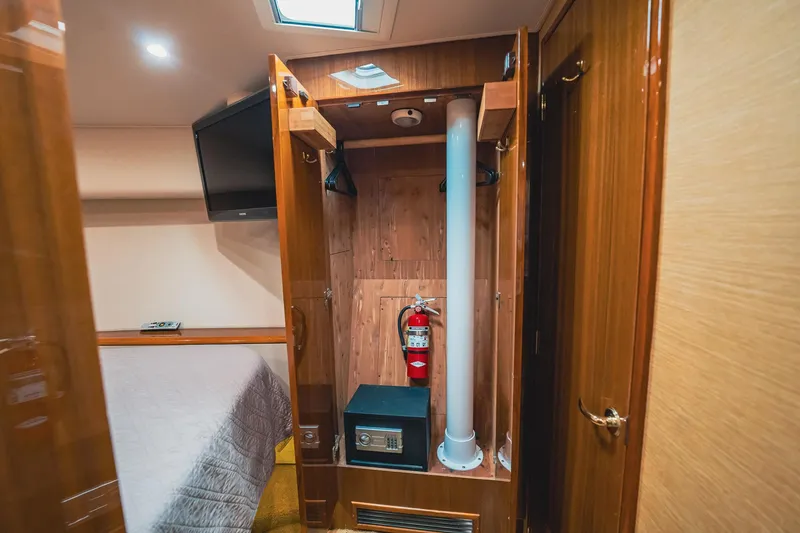 Slide: The Image of 2005 Viking 48 Convertible interior with closet, safe, and fire extinguisher. - 26
