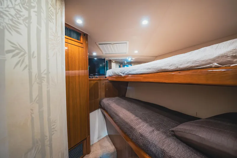 Slide: The Image of Interior of 2005 Viking 48 Convertible yacht with cozy bunk beds and wooden cabinetry. - 30
