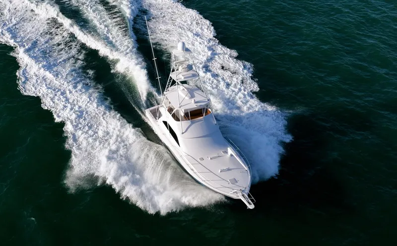 Slide: The Image of 2005 Viking 48 Convertible yacht cruising swiftly on open water. - 35