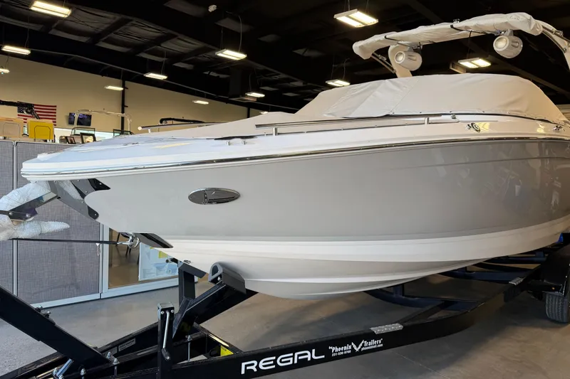 Slide: The Image of 2026 Regal LS6 Surf boat on trailer in showroom setting. - 10