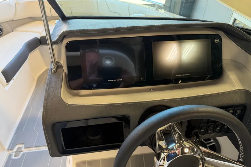 Slide: The Image of 2026 Regal LS6 Surf boat dashboard with dual Volvo Penta displays and steering wheel. - 17