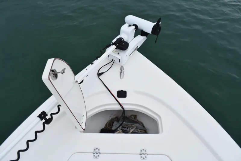 Slide: The Image of 2020 Sea Pro 208 Bay boat with open storage compartment and trolling motor on calm water. - 13