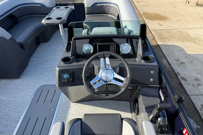 Slide: The Image of 2026 Bennington 22 S Sport Quad Bench boat interior with steering wheel and seating. - 17