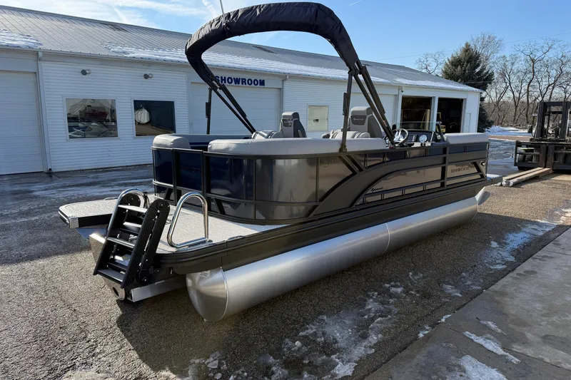 Slide: The Image of 2026 Bennington 22 S Sport Quad Bench pontoon boat outside showroom on a sunny day. - 5