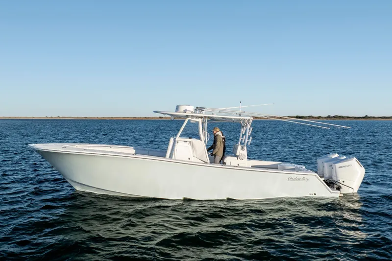 Slide: The Image of 2024 Onslow Bay 33 TE boat on open water, featuring sleek design and twin Mercury engines. - 1