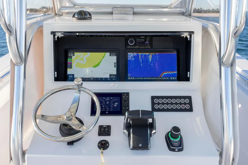 Slide: The Image of 2024 Onslow Bay 33 TE boat dashboard with navigation screens and controls. - 24
