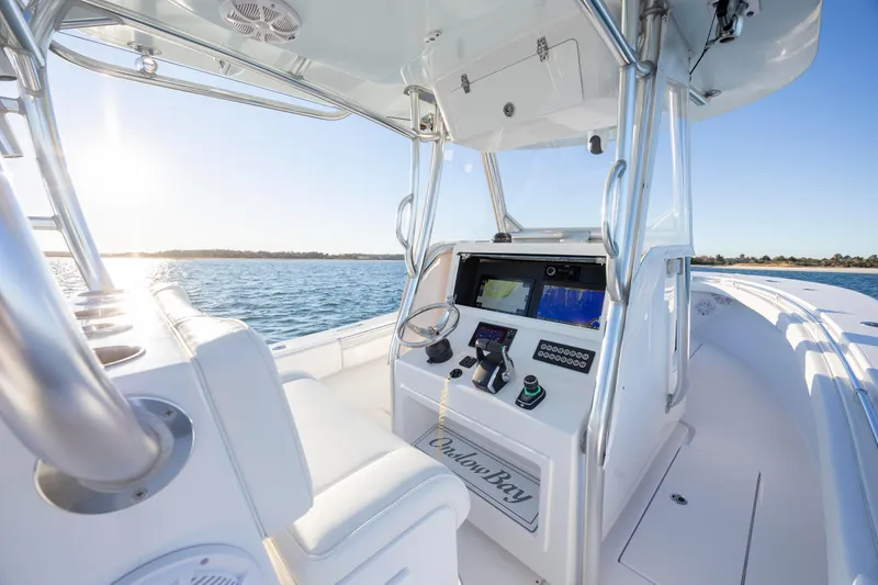Slide: The Image of 2024 Onslow Bay 33 TE boat interior with modern controls, steering wheel, and ocean view. - 26