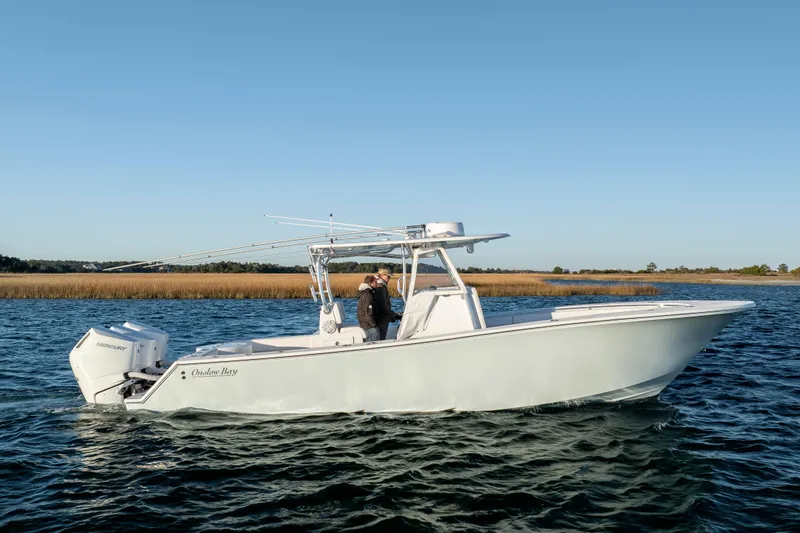 Slide: The Image of 2024 Onslow Bay 33 TE boat cruising on calm waters under clear blue sky. - 5