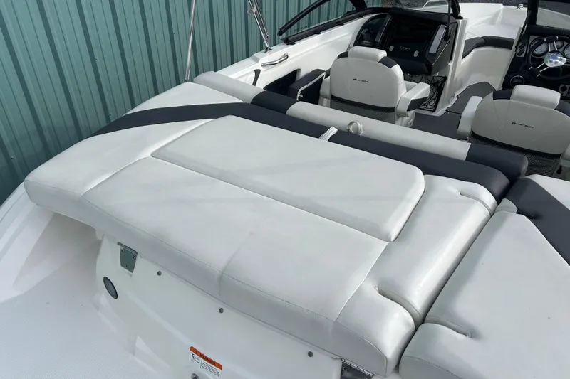 Slide: The Image of 2016 Larson LX 205S IO boat interior with white cushioned seating and modern dashboard. - 12