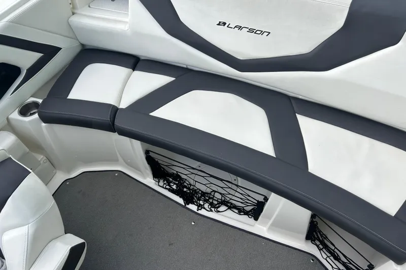 Slide: The Image of 2016 Larson LX 205S IO boat interior with black and white seating and storage netting. - 15