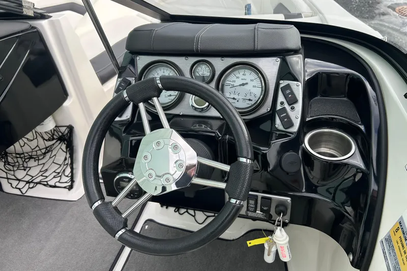 Slide: The Image of Steering wheel and dashboard of 2016 Larson LX 205S IO boat, featuring gauges and controls. - 19