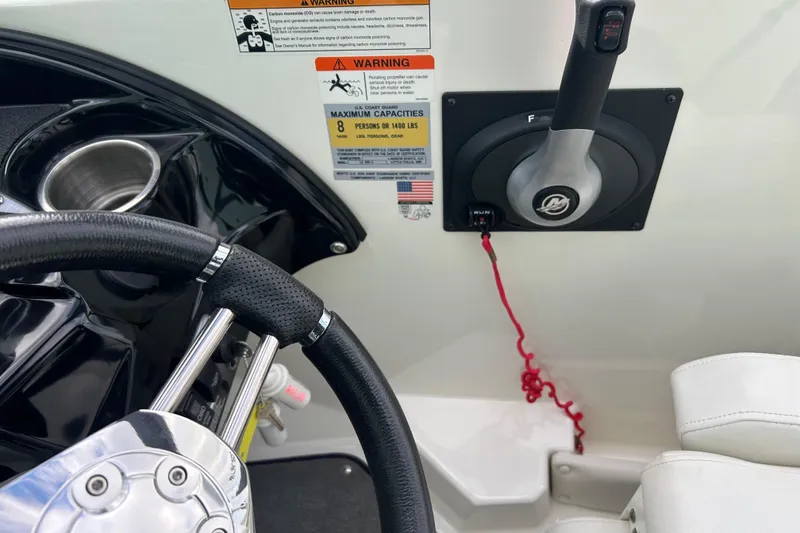 Slide: The Image of Steering wheel and throttle of 2016 Larson LX 205S IO boat with safety warnings. - 22