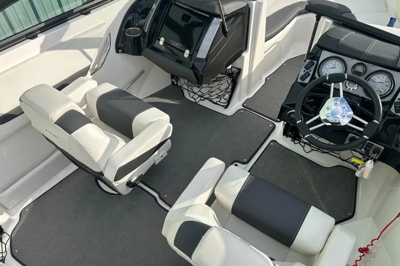 Slide: The Image of 2016 Larson LX 205S IO boat interior with steering wheel and seating. - 23