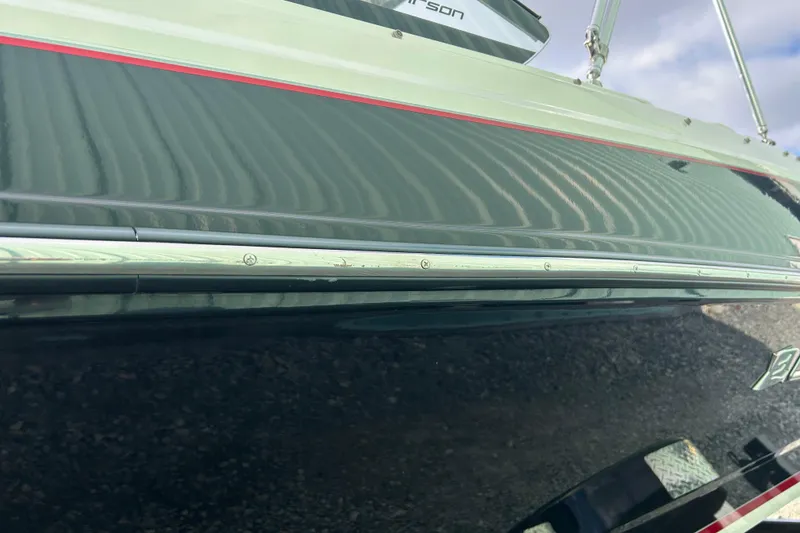 Slide: The Image of 2016 Larson LX 205S IO boat hull with sleek design and red accent stripe. - 9