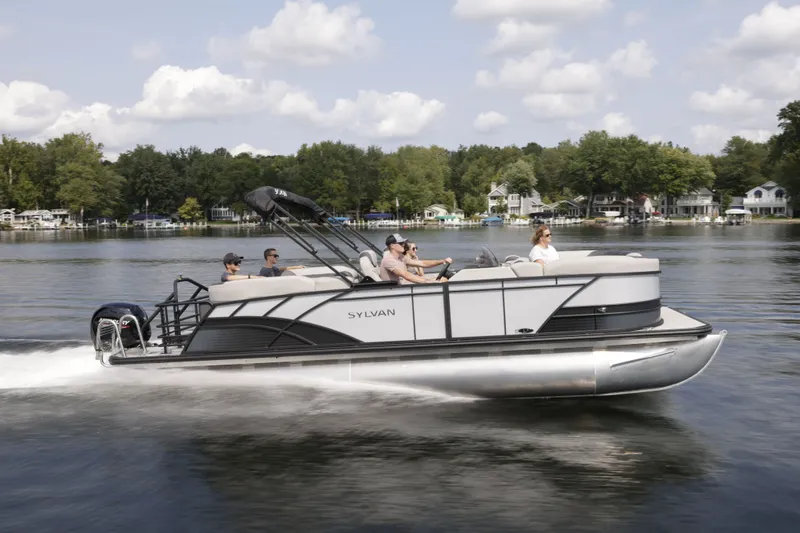 Slide: The Image of 2026 Sylvan L-3 ULZ pontoon boat cruising on a serene lake. - 1