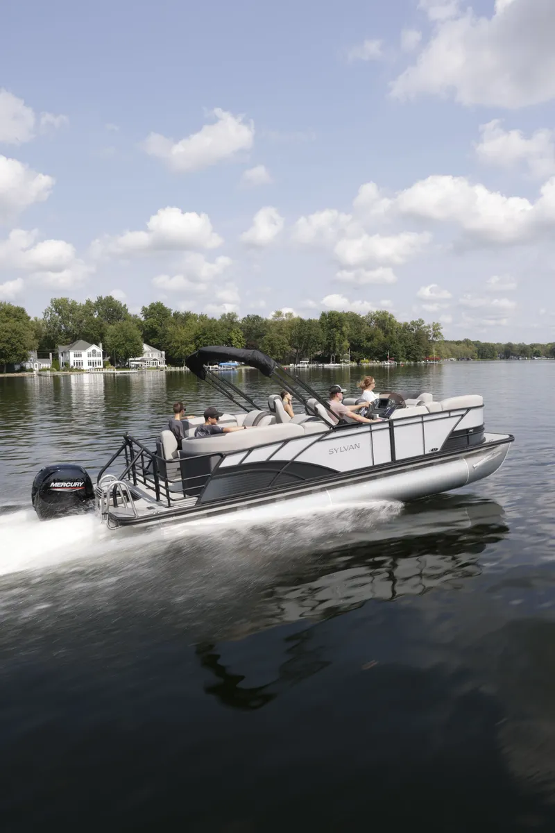 Slide: The Image of Sylvan L-3 ULZ 2026 pontoon boat cruising on a serene lake. - 3
