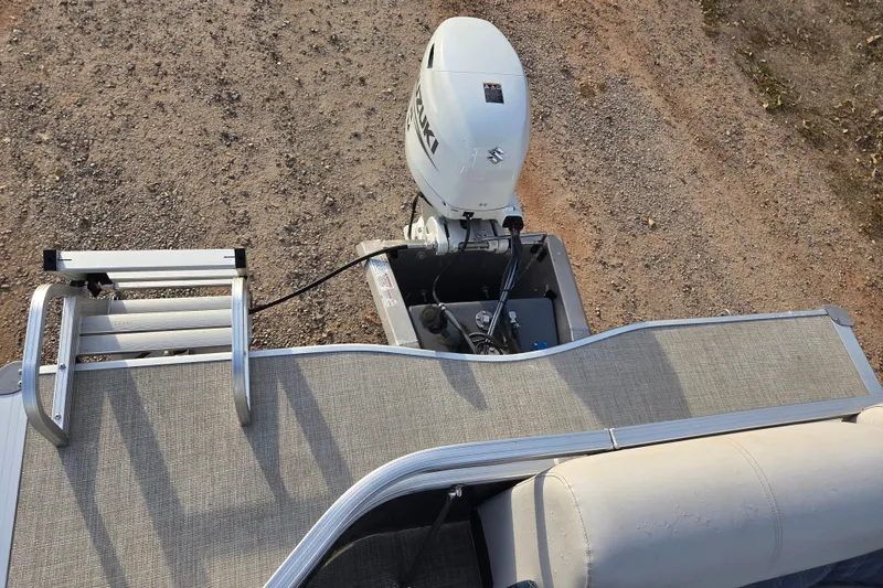 Slide: The Image of 2022 Nepallo 20TL boat with Suzuki outboard motor and aluminum ladder on gravel surface. - 6